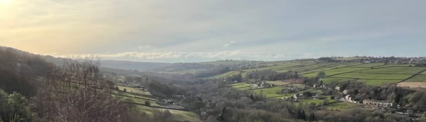 View of landscape with sun in top left, showing Rivelin Valley in Sheffield, from Carver Fields.
